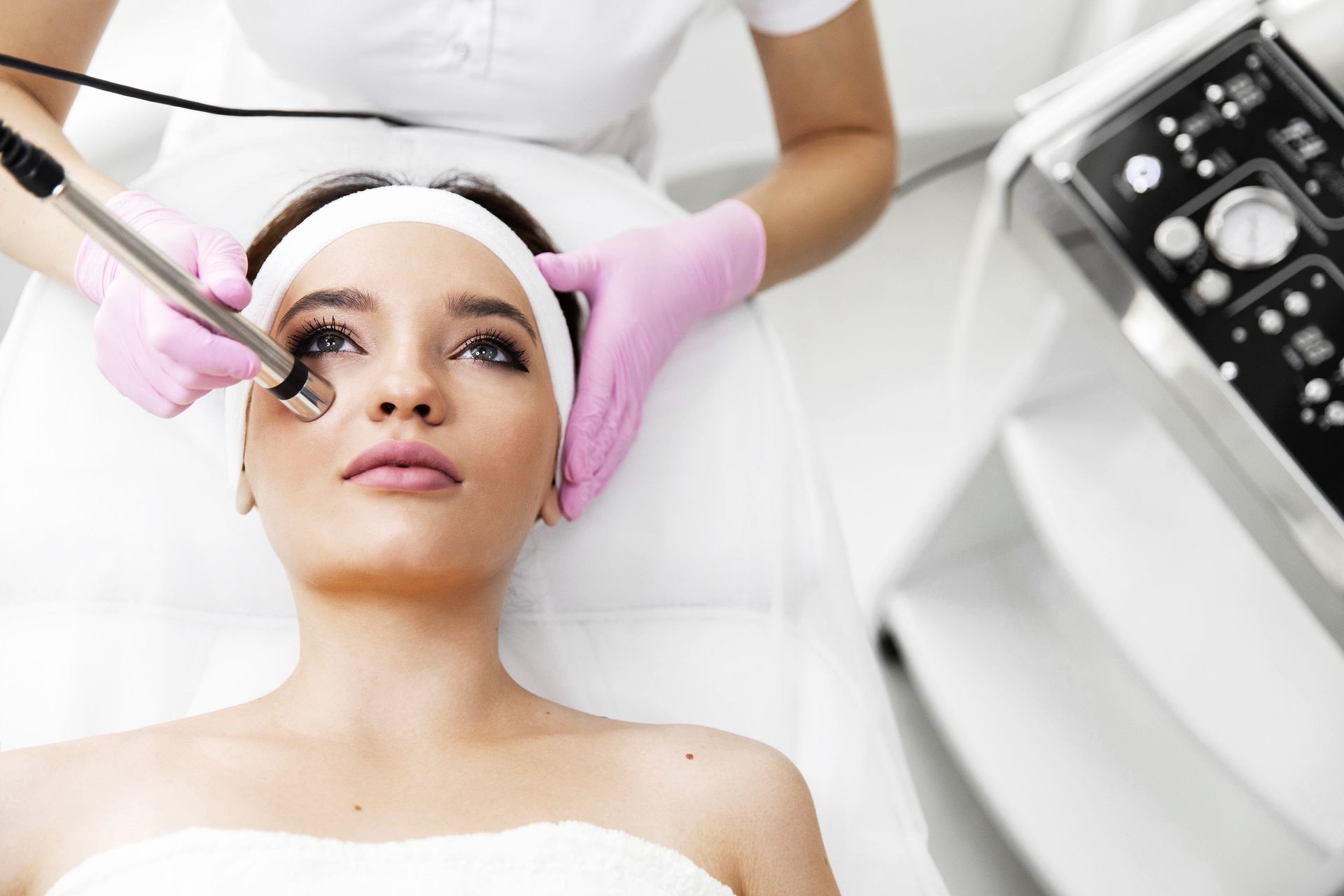 A woman came to laser hair removal facial. The woman lies and smiles, the doctor leads him in the face with a modern laser epilator. They are in the modern clinic.close up